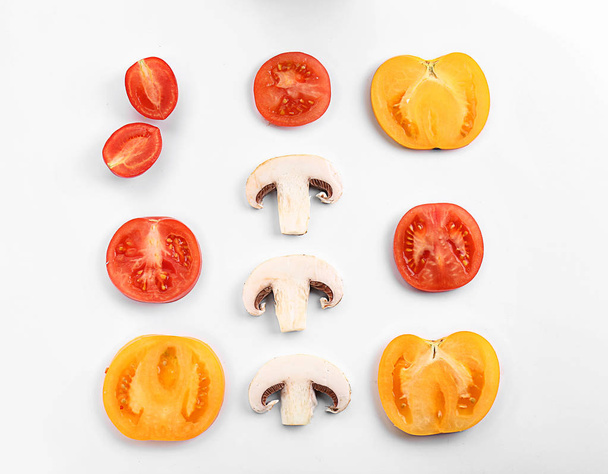 Cut tomatoes and mushrooms on white background, flat lay - Фото, зображення