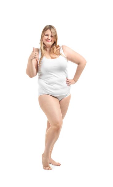 Beautiful plus size girl in underwear showing thumb-up gesture on white background. Concept of body positivity - Photo, Image