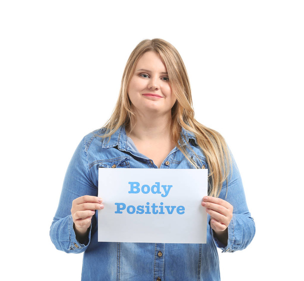 Beautiful plus size girl holding paper sheet with text BODY POSITIVE on white background - Zdjęcie, obraz