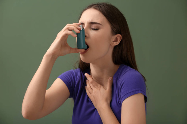 Młoda kobieta z inhalatorem z atakiem astmy na tle koloru - Zdjęcie, obraz