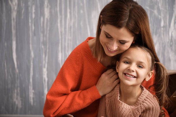 Retrato de madre feliz con hija sobre fondo gris
 - Foto, Imagen