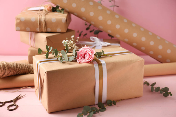 Festive gift box and wrapping paper on table - Fotoğraf, Görsel