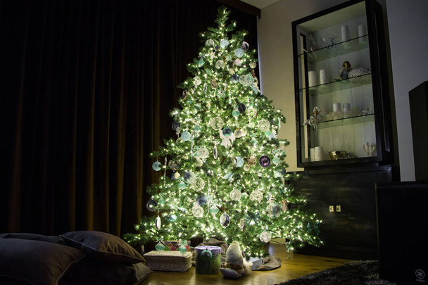 Árbol de Navidad alto con adornos y guirnaldas
 - Foto, Imagen