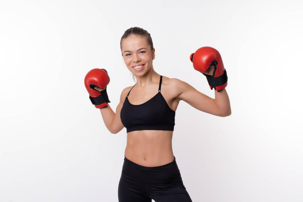 Vidám fitness nő pózol a boksz-kesztyűket felett fehér háttér - Fotó, kép