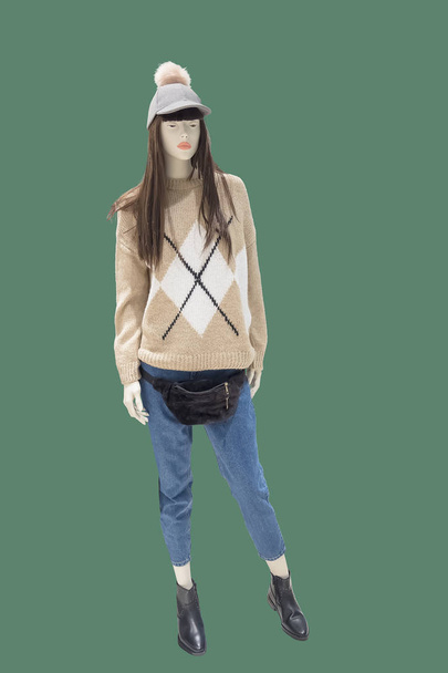 Full-length vrouwelijke etalagepop dragen van de trui en blue jeans, geïsoleerd op groene achtergrond. Geen merknamen of auteursrecht objecten. - Foto, afbeelding