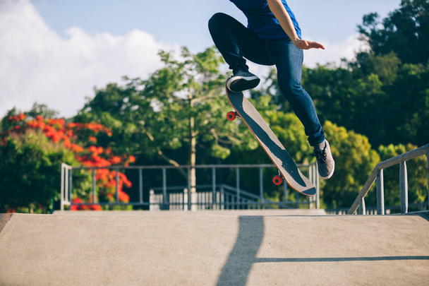 Skateboarder jumping in the skatepark at sunny day - Foto, imagen