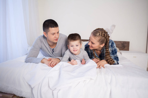 mom dad and young son sleep on the bed in the bedroom - 写真・画像