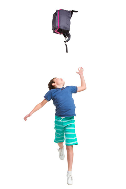 Full length portrait of cute little kid in stylish clothes jumping with bag - Foto, Bild