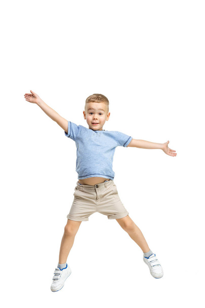 Adorable boy jumping and raises his hands up. - Foto, Imagen