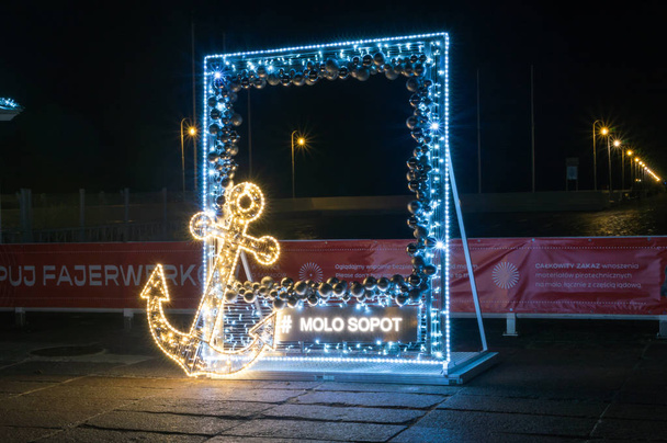 Sopot, Polonia - 25 dicembre 2018: Sopot illuminato cornice all'ingresso del molo di legno sul Mar Baltico di notte
. - Foto, immagini