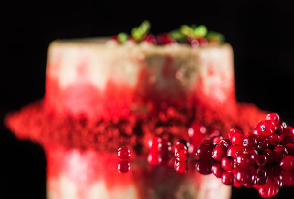 selective focus of white cake decorated with mint leaves near red currants isolated on black - Photo, Image