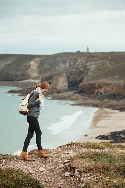 girl traveler on the background Cap Frehel. typical Brittany coast in the north of Franc - Φωτογραφία, εικόνα
