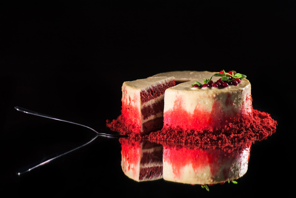 menta levelek és a piros ribiszke közelében spatula elszigetelt fekete díszített fehér torta - Fotó, kép