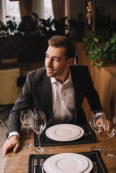 handsome man in suit waiting for girlfriend in restaurant  - Foto, Imagem