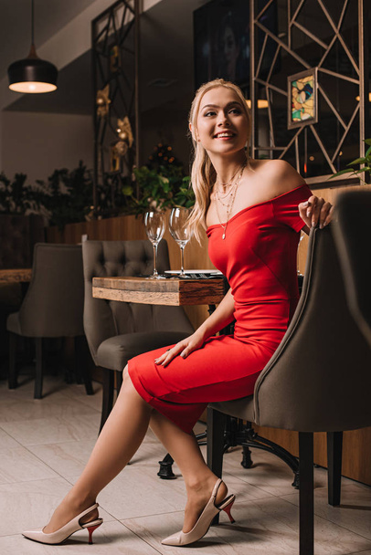attractive girl sitting and smiling while waiting for boyfriend - Fotografie, Obrázek