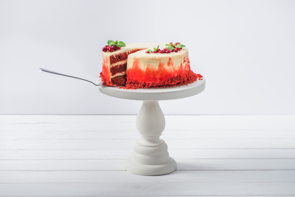 bílý dort s rybízem a mátou listy na stojanu zdobené špachtle izolované na bílém  - Fotografie, Obrázek