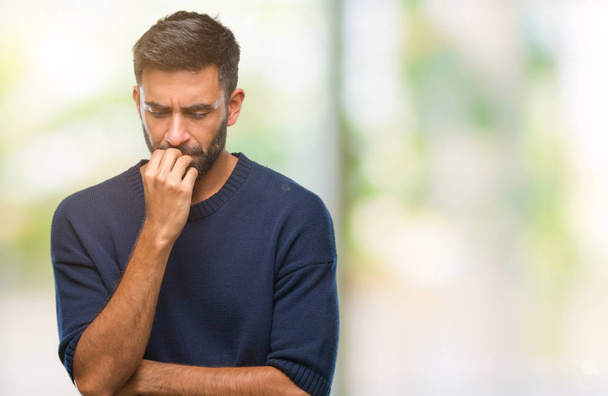 Yetişkin İspanyol adam stresli ve gergin ile izole arka plan üzerinde tırnak ısırma dudaklarından eller. Anksiyete sorunu. - Fotoğraf, Görsel