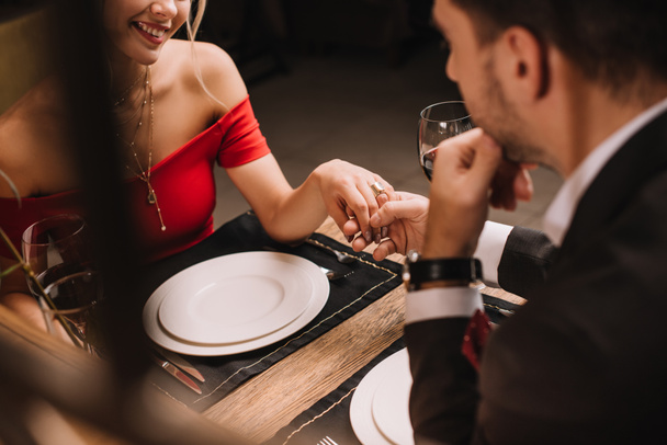 vista recortada de la pareja cogida de la mano en el restaurante durante la cena
  - Foto, imagen