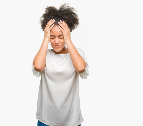 Молодих афро Американку над ізольованих фону, страждають від головного болю, відчайдушні і підкреслив, тому що біль і мігрень. Руки на голову. - Фото, зображення