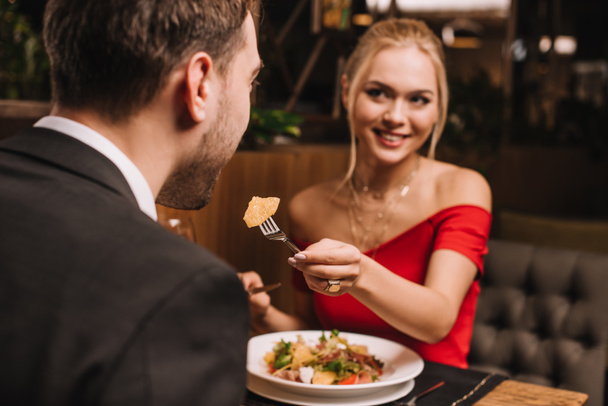 atractiva novia alimentación novio en restaurante
  - Foto, Imagen
