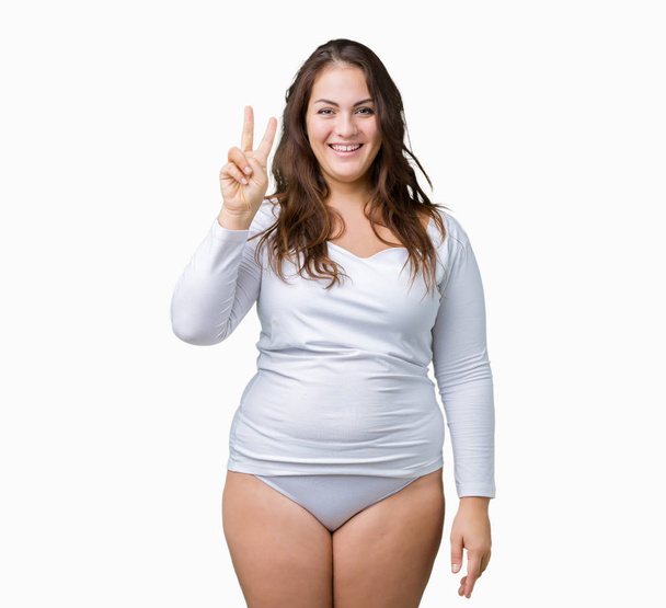 Beautiful plus size young overwight woman wearing white underwear over isolated background showing and pointing up with fingers number two while smiling confident and happy. - Fotografie, Obrázek