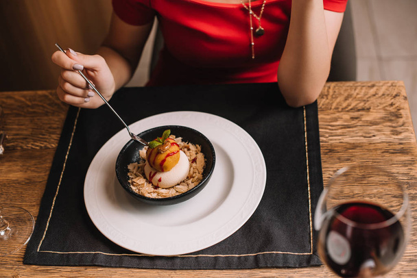 cropped view of woman holding spoon near tasty dessert in bowl - Photo, image