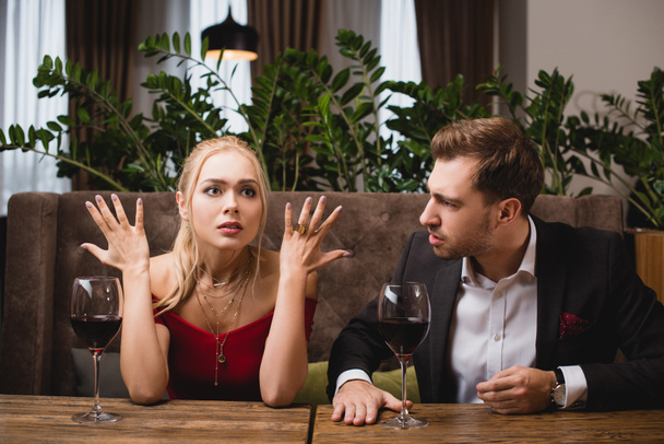 shocked woman gesturing near boyfriend in restaurant  - Fotografie, Obrázek