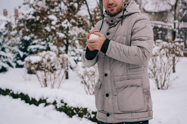 обрізаний вид людини, що тримає сніжку в руках взимку
  - Фото, зображення