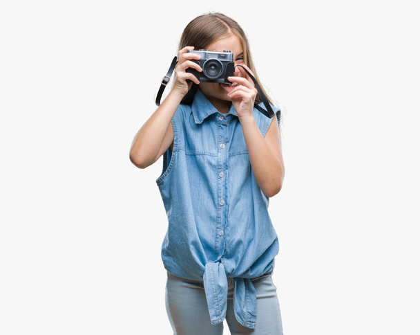 Young beautiful girl taking photos using vintage camera over isolated background with a happy face standing and smiling with a confident smile showing teeth - Fotografie, Obrázek
