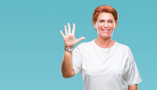 Atrractive senior caucasian redhead woman over isolated background showing and pointing up with fingers number five while smiling confident and happy. - Фото, зображення
