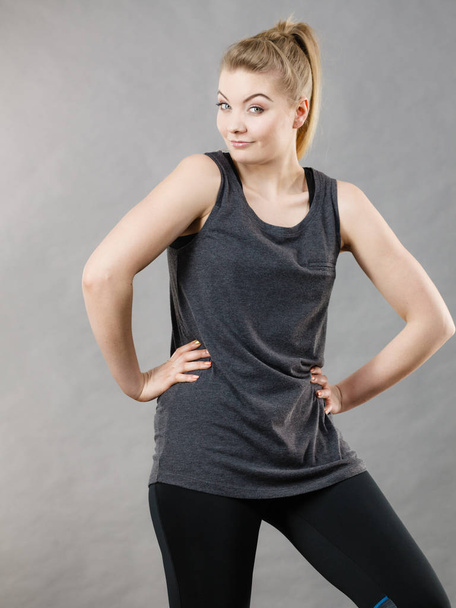 Happy woman wearing black tank top and leggings smiling having good mood. Sporty outfit - Fotografie, Obrázek
