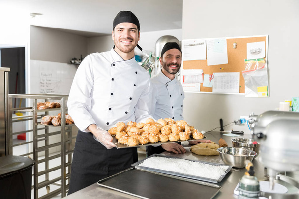 Portret van mannelijke chef-koks bereiden chouxs in bakkerij - Foto, afbeelding