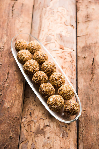 Tilgul Laddu ou Til Gul bolas para makar sankranti, é um alimento saudável feito com gergelim, amendoins esmagados e jaggery. servido em uma tigela. foco seletivo mostrando detalhes
. - Foto, Imagem