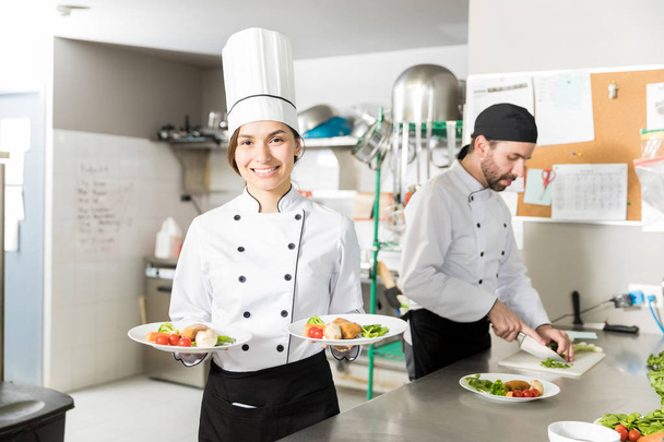 Confident professional chef with chicken and vegetables in kitchen - Photo, Image
