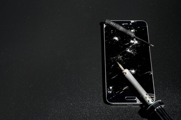 Repair smartphones with a broken screen on a dark background - Valokuva, kuva