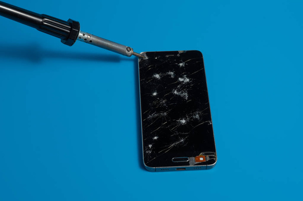 Repair smartphones with a broken screen on a blue background - Valokuva, kuva
