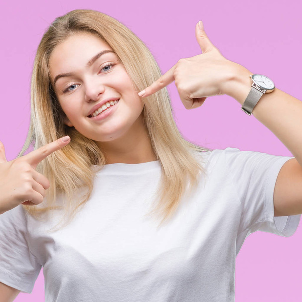 Young caucasian woman over isolated background smiling confident showing and pointing with fingers teeth and mouth. Health concept. - Φωτογραφία, εικόνα