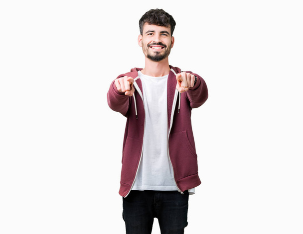 Молодой красивый мужчина на изолированном фоне указывает на тебя и камеру пальцами, улыбаясь позитивно и весело
 - Фото, изображение