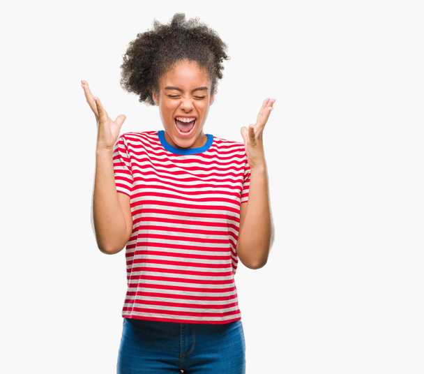 Nuori afro amerikkalainen nainen yli eristetty tausta juhlii hullu ja hullu menestystä kädet kohotetaan ja suljetut silmät huutaa innoissaan. Voittajan käsite
 - Valokuva, kuva