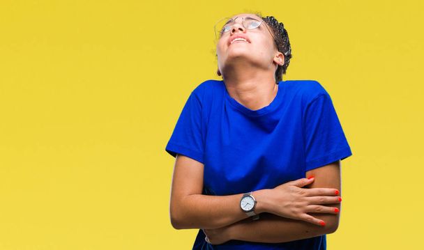 Молодая косичка африканская американка в очках на изолированном фоне с рукой на животе, потому что тошнота, болезненное заболевание чувствует себя нездоровым. Концепция Ache
. - Фото, изображение
