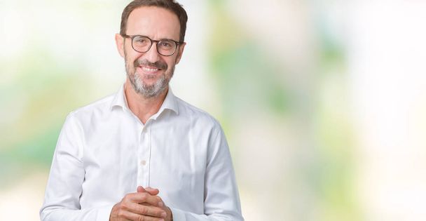Handsome middle age elegant senior business man wearing glasses over isolated background Hands together and fingers crossed smiling relaxed and cheerful. Success and optimistic - Foto, immagini