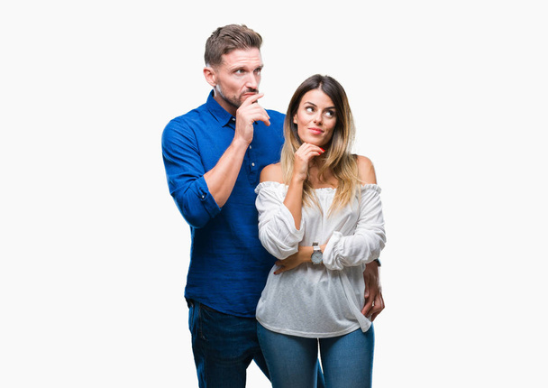 Young couple in love over isolated background with hand on chin thinking about question, pensive expression. Smiling with thoughtful face. Doubt concept. - Foto, Imagem