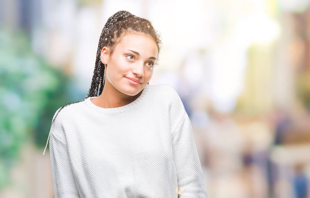 若い編んだ髪アフリカ系アメリカ人女の子の笑顔見ている側と見つめて離れて思考分離の背景に冬のセーターを着て. - 写真・画像