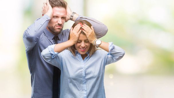 Young workers business couple over isolated background suffering from headache desperate and stressed because pain and migraine. Hands on head. - Foto, Bild