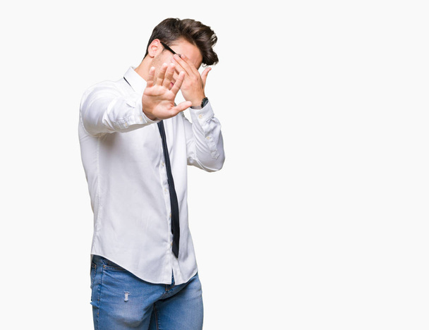 Young business man wearing glasses over isolated background covering eyes with hands and doing stop gesture with sad and fear expression. Embarrassed and negative concept. - Photo, Image