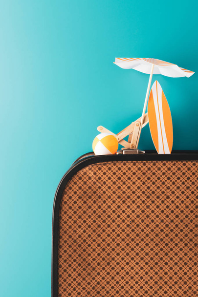 Kesäsateenvarjo puinen leposohva oranssi surffilauta ja puhallettava pallo matkatavarat sinisellä pohjalla
 - Valokuva, kuva