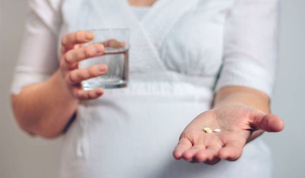 Embarazada irreconocible mostrando pastillas
 - Foto, Imagen
