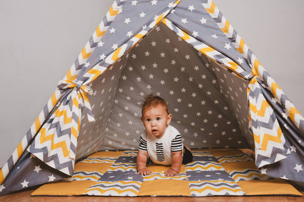 Hämmästyttävä söpö vauva istuu värikäs teltta
 - Valokuva, kuva