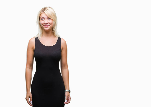 Young beautiful blonde attractive woman wearing elegant dress over isolated background smiling looking side and staring away thinking. - Photo, Image