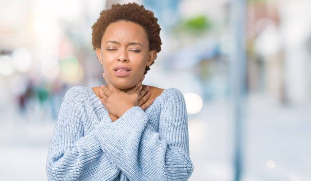Young beautiful african american woman wearing a sweater over isolated background shouting and suffocate because painful strangle. Health problem. Asphyxiate and suicide concept. - Foto, imagen